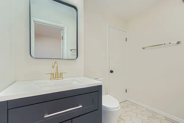 a bathroom with a toilet a sink a vanity and mirror