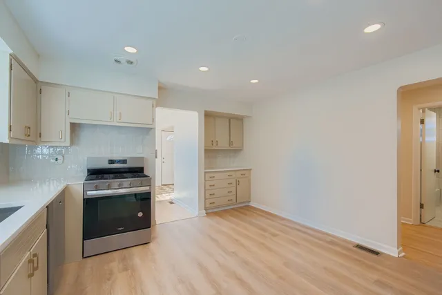 a kitchen with a stove top oven and cabinets