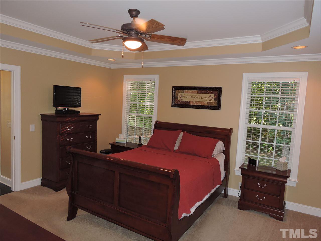 170 Fletcher Ridge Road Timberlake, NC 27583 - Photo 15 of 25 a bedroom with a bed and a flat tv screen on dresser