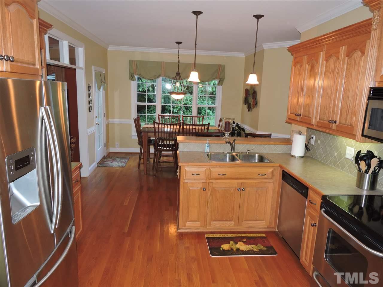 170 Fletcher Ridge Road Timberlake, NC 27583 - Photo 5 of 25 a kitchen with stainless steel appliances granite countertop a refrigerator a sink dishwasher a stove and white countertops with wooden floor