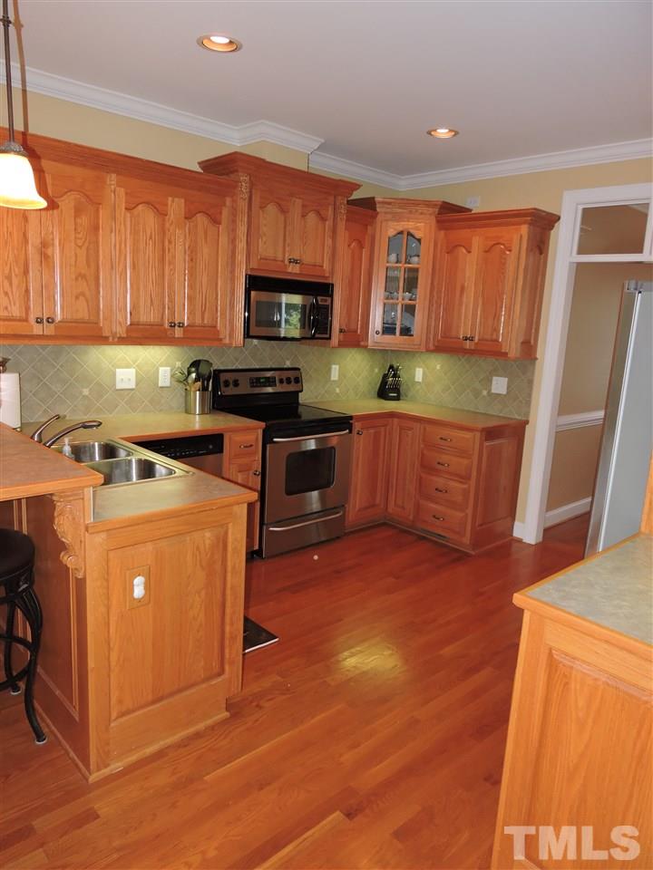 170 Fletcher Ridge Road Timberlake, NC 27583 - Photo 7 of 25 a kitchen with stainless steel appliances a stove top oven a sink a refrigerator a window