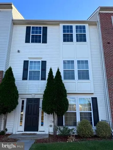 a front view of a house with a garden and plants