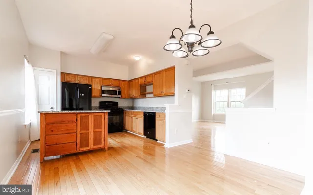 a kitchen with stainless steel appliances granite countertop a refrigerator a stove top oven a sink and dishwasher