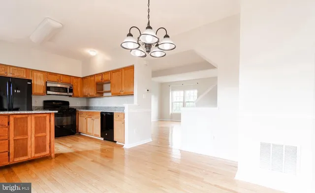 a kitchen with stainless steel appliances kitchen island granite countertop a sink counter space and cabinets