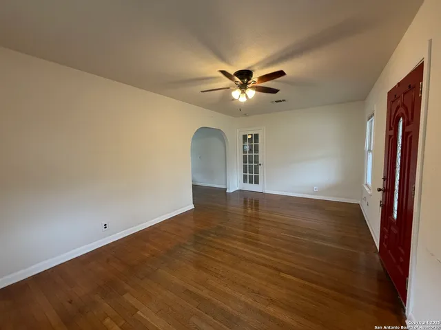 an empty room with wooden floor and window