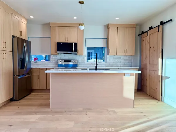 a kitchen with stainless steel appliances granite countertop a refrigerator stove top oven and sink