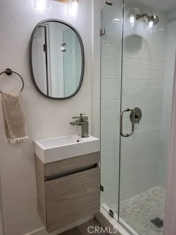a bathroom with a sink a mirror a vanity and shower