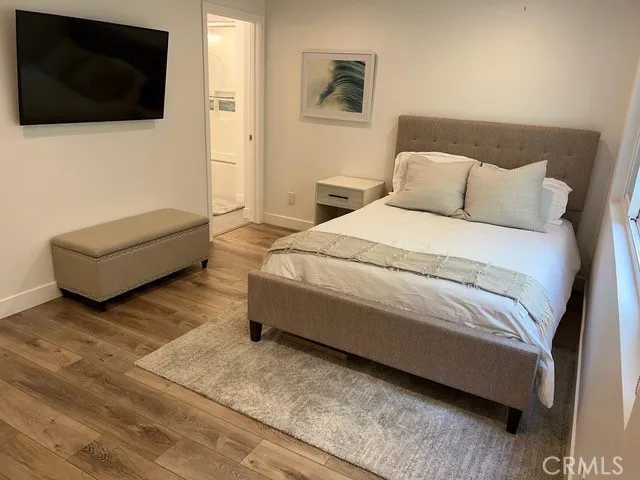 a spacious bedroom with a bed and a flat screen tv