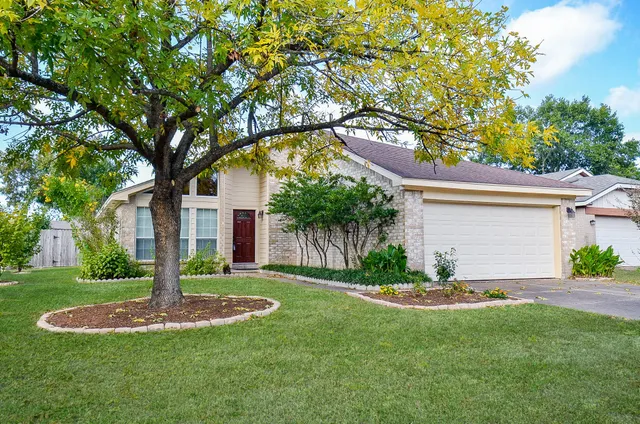 a front view of a house with a yard and tree