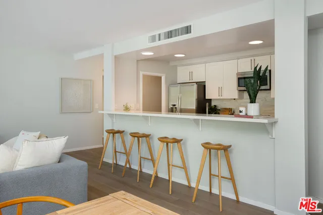 a kitchen with a table chairs sink and cabinets