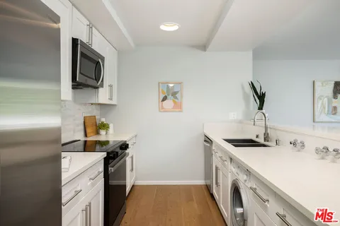 a kitchen with a sink stainless steel appliances and cabinets