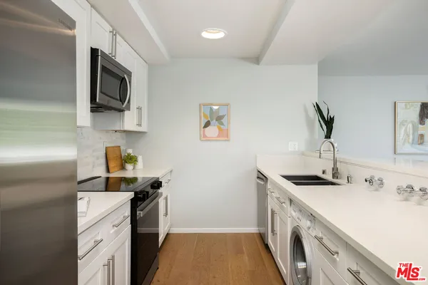 a kitchen with a sink stainless steel appliances and cabinets