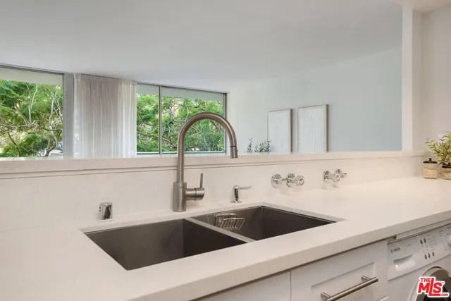 a view with a sink a counter top space and a window