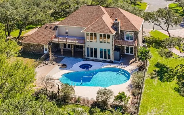 an aerial view of a house with swimming pool garden and patio
