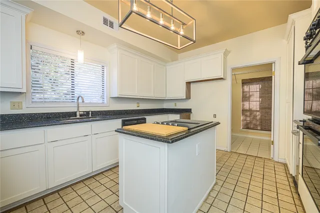 a kitchen with granite countertop a sink and a stove