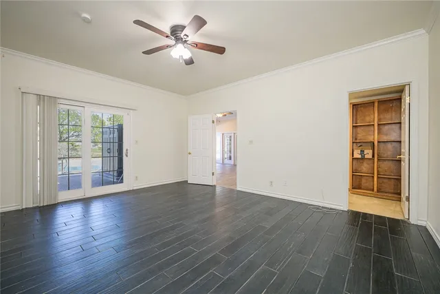 a view of an empty room with a window and wooden floor