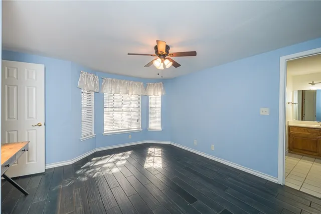 a view of a room with wooden floor and a chandelier fan