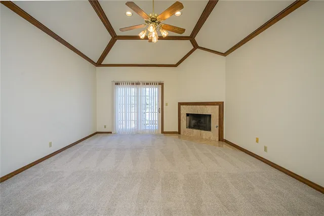 an empty room with windows and fireplace