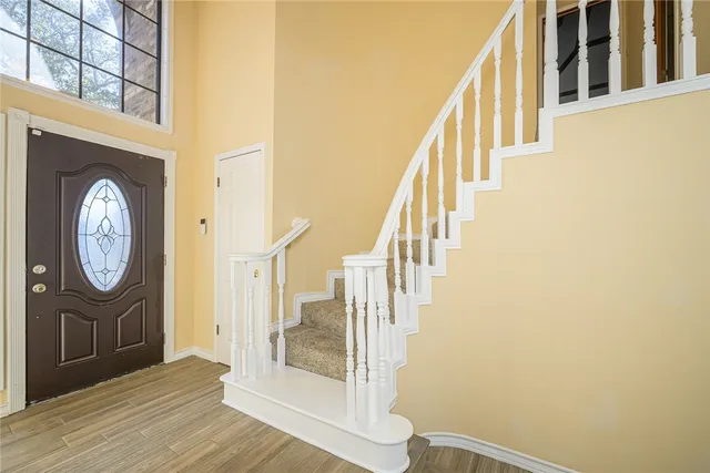 a view of a hallway with wooden floor and entryway