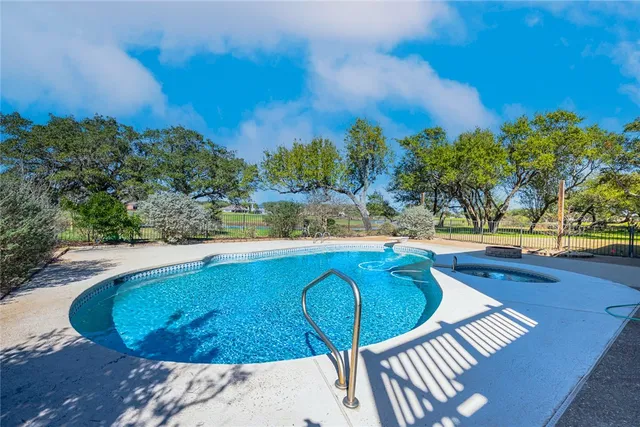 a view of a swimming pool with a yard and seating space