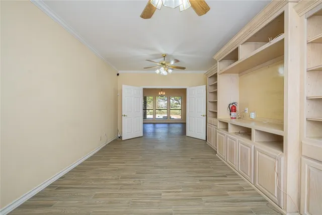 a view of a hallway with wooden floor and a kitchen