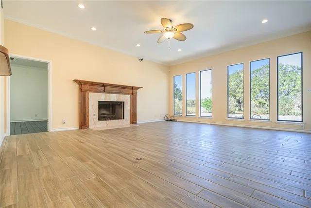 a view of an empty room with a window and wooden floor