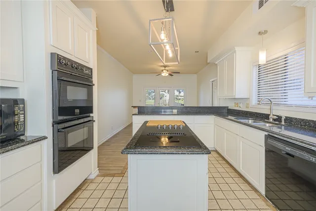 a kitchen with granite countertop a stove and a sink