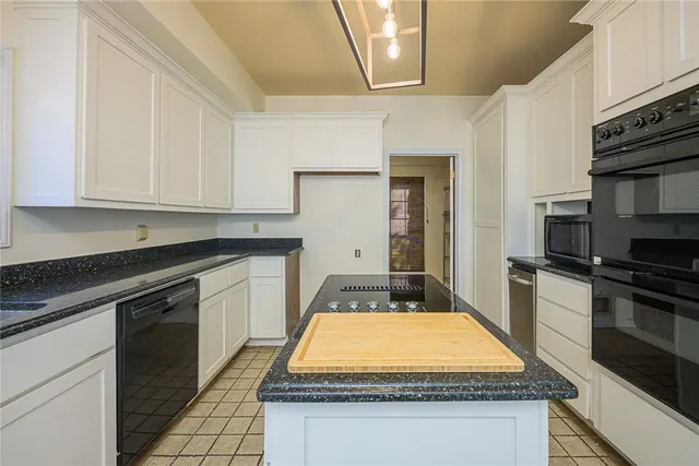 a kitchen with kitchen island granite countertop stainless steel appliances a stove sink and cabinets