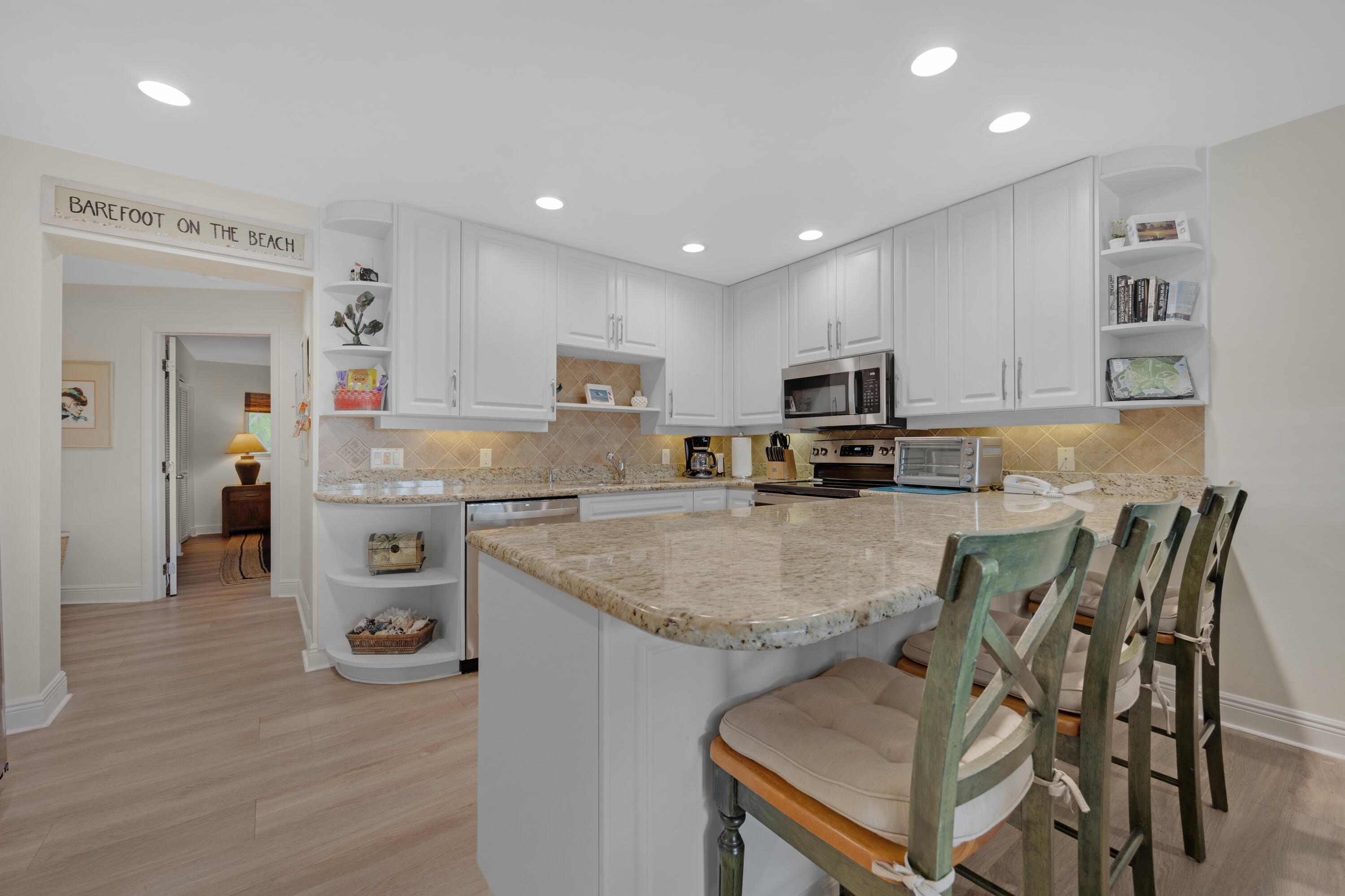 18 Anchor Drive, Unit B Key Largo, FL 33037 - Photo 12 of 17 a kitchen with stainless steel appliances granite countertop a table chairs sink and cabinets