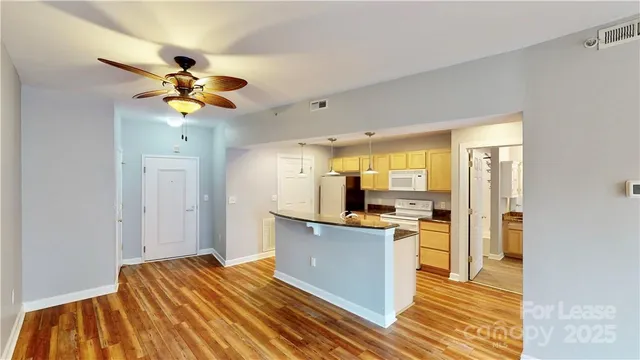 a view of a kitchen with a sink wooden floor and a window