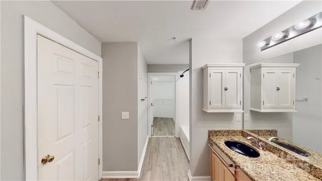 a kitchen with white cabinets and sink