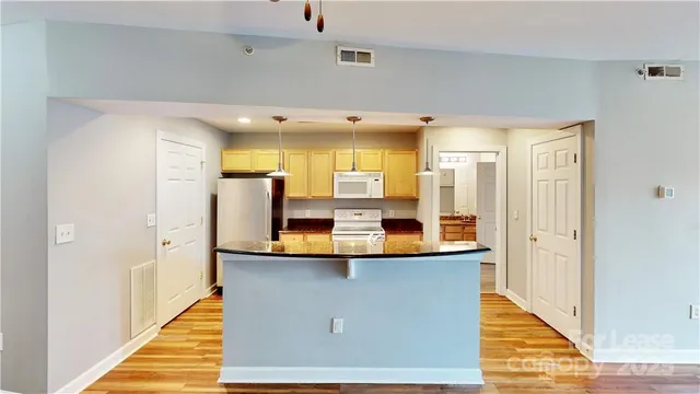 a view of kitchen with stainless steel appliances kitchen island sink and refrigerator