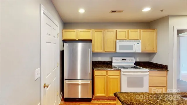 a kitchen with stainless steel appliances granite countertop a refrigerator sink and cabinets