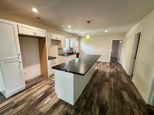 a kitchen with sink a refrigerator and wooden floor