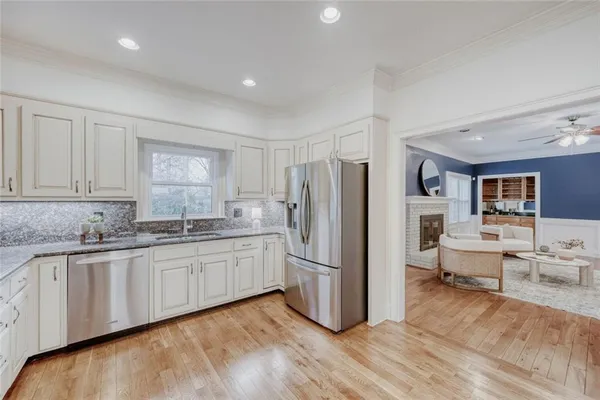 a kitchen with stainless steel appliances granite countertop a refrigerator and a stove top oven
