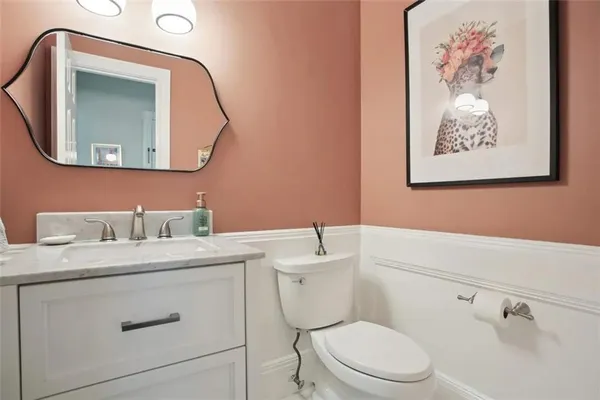 a bathroom with a toilet a sink and mirror