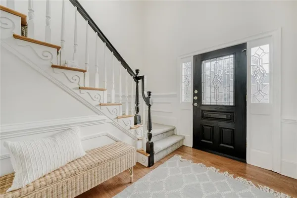 a view of entryway bedroom and hall with wooden floor