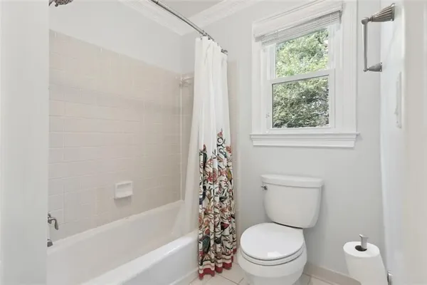 a white toilet sitting next to a bath tub