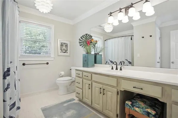 a spacious bathroom with a toilet a sink and a mirror