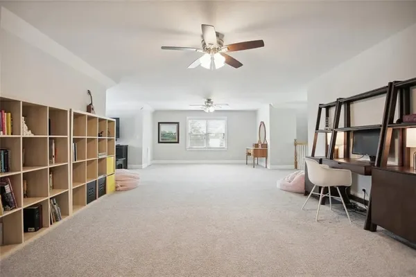 a furnished livingroom with a large window and book shelf