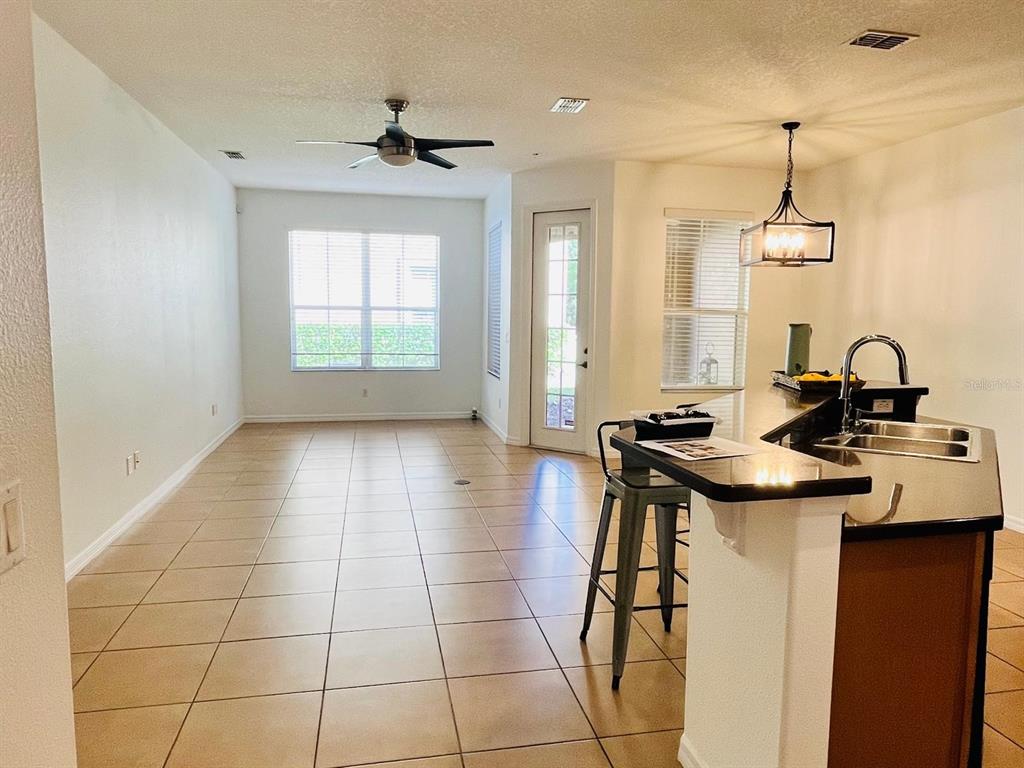 3655 Zuma Way Orlando, FL 32839 - Photo 1 of 1 a kitchen with a sink a stove cabinets and a dining table
