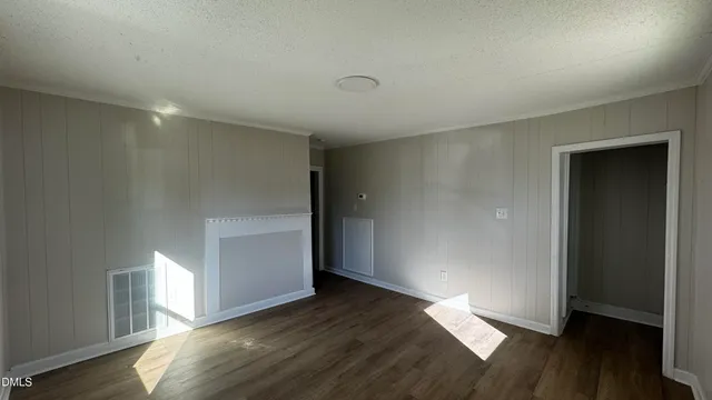an empty room with wooden floor and window