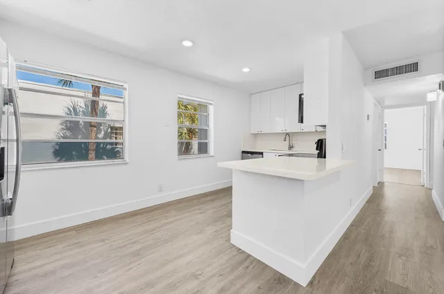 a kitchen with stainless steel appliances cabinets a sink and a large window
