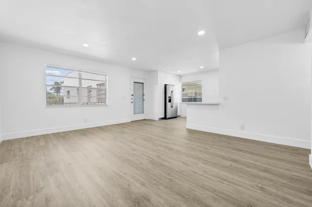 a view of empty room with wooden floor and window