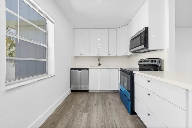 a kitchen with a sink a stove and cabinets
