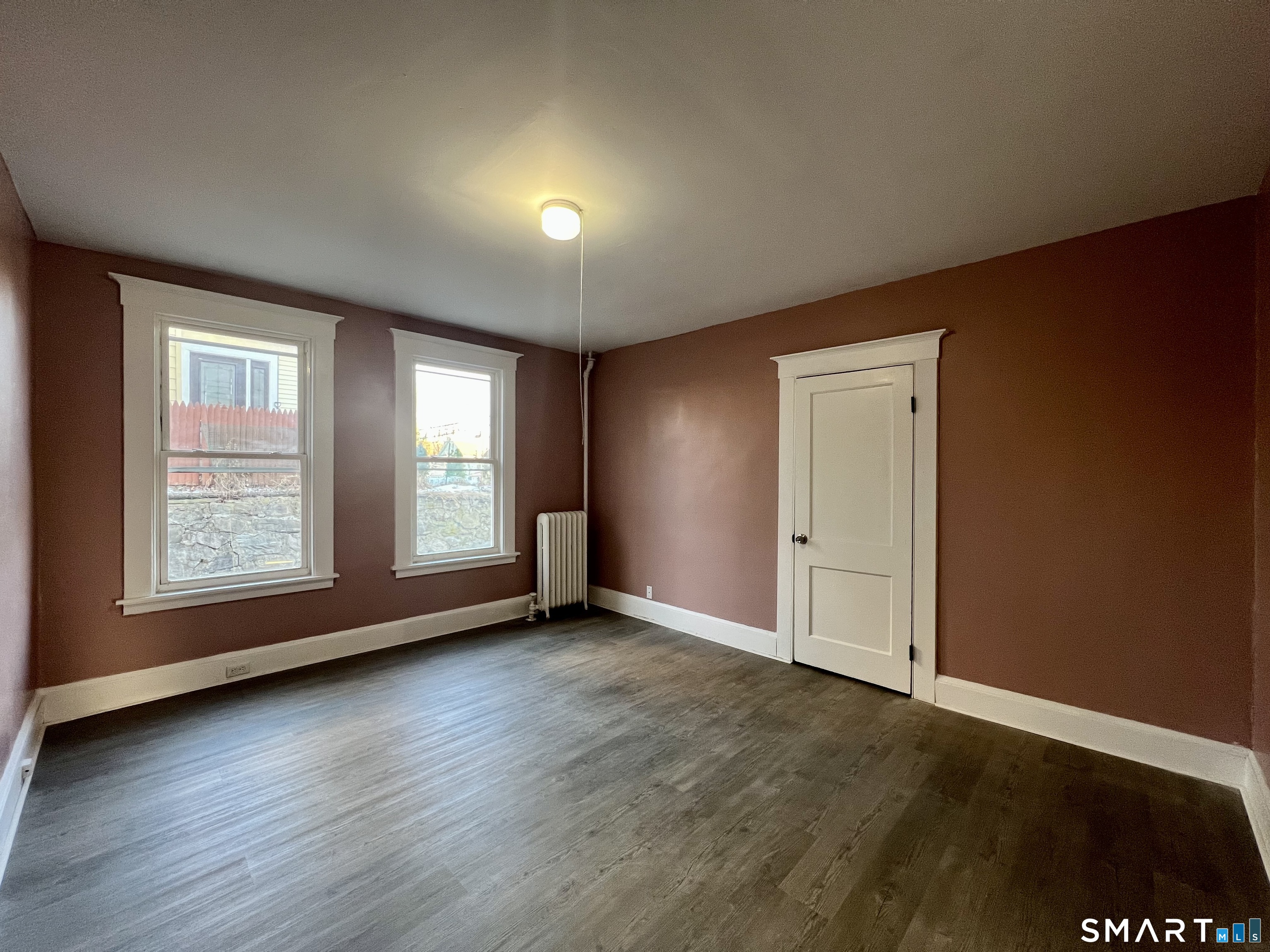 154 High Street Torrington, CT 06790 - Photo 13 of 36 an empty room with wooden floor and windows