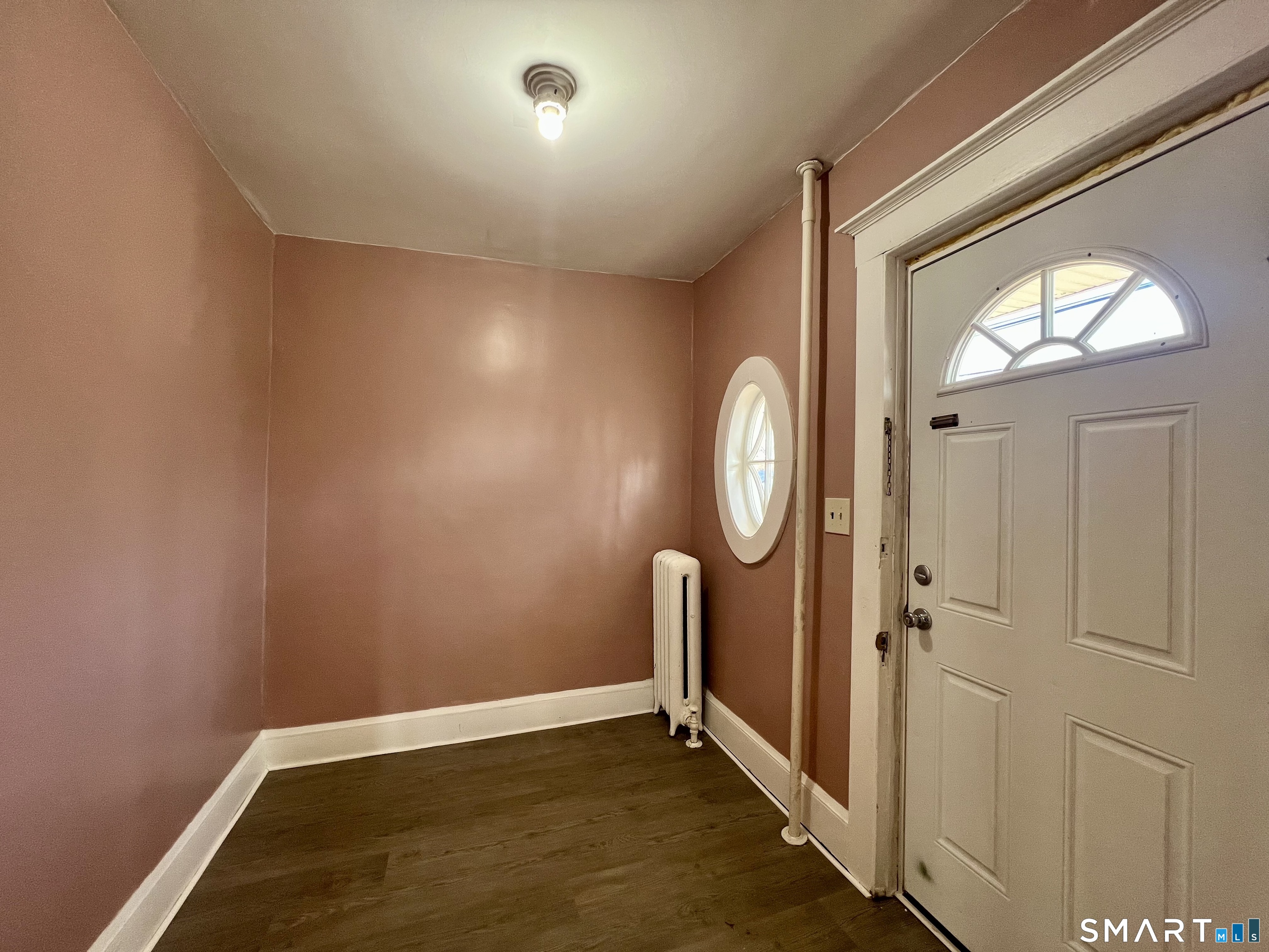 154 High Street Torrington, CT 06790 - Photo 7 of 36 an empty room with wooden floor and a mirror