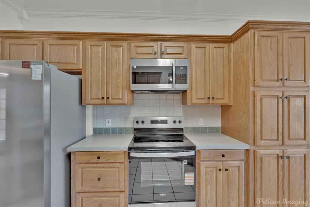 1413 Magnolia Ridge Bossier City, LA 71112 - Photo 9 of 29 a kitchen with stainless steel appliances granite countertop a stove a refrigerator and a microwave