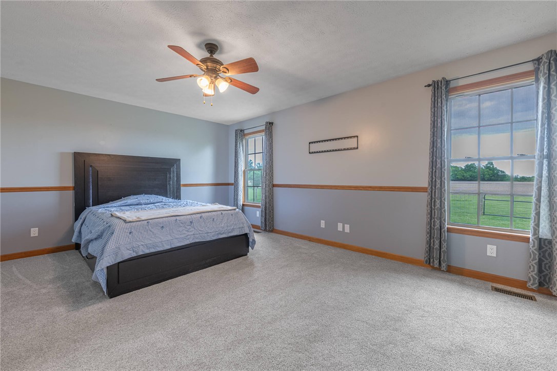 2645 Vance Road St. Paris, OH 43072 - Photo 23 of 35 This spacious sleeping chamber features ample natural light and a comforting ceiling fan for optimal airflow.