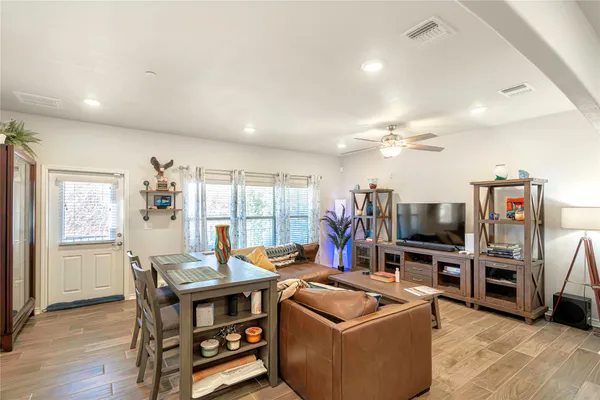 a living room with furniture a flat screen tv and kitchen view